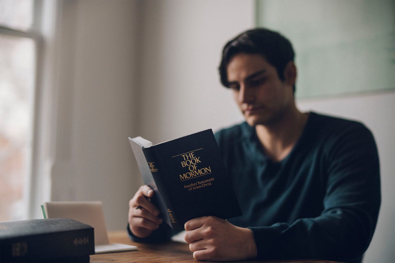 Mies lukemassa Mormonin kirjaa
